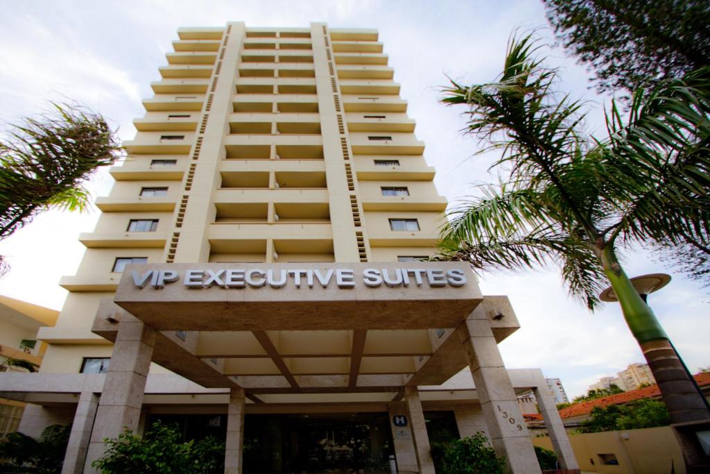 um edifício alto com o cartaz das Suites Executivas em Vip Executive Suites Maputo em Maputo