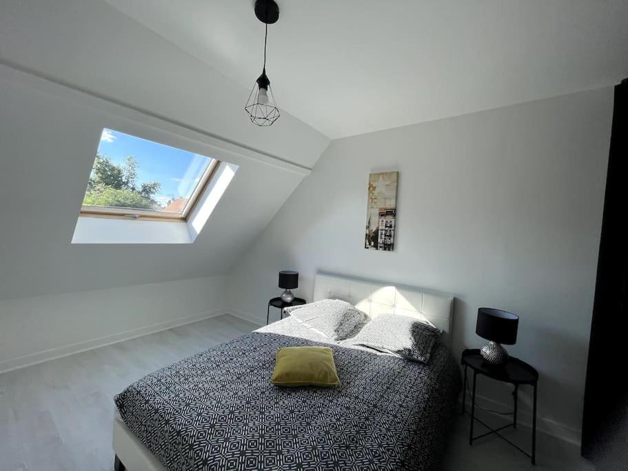Habitación blanca con cama y ventana en Maison entière 5 mn Roissy CDG/15 mn Parc Astérix en Le Mesnil-Amelot