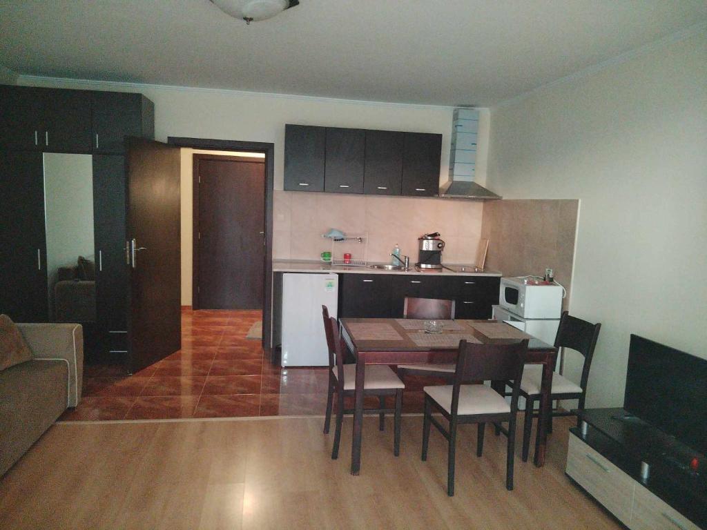 a kitchen and living room with a table and chairs at Тайната квартира - The Secret apartment in Pamporovo