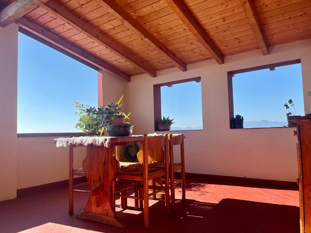 een kamer met ramen en een tafel en stoelen bij Casa di Rosy in San Sperate