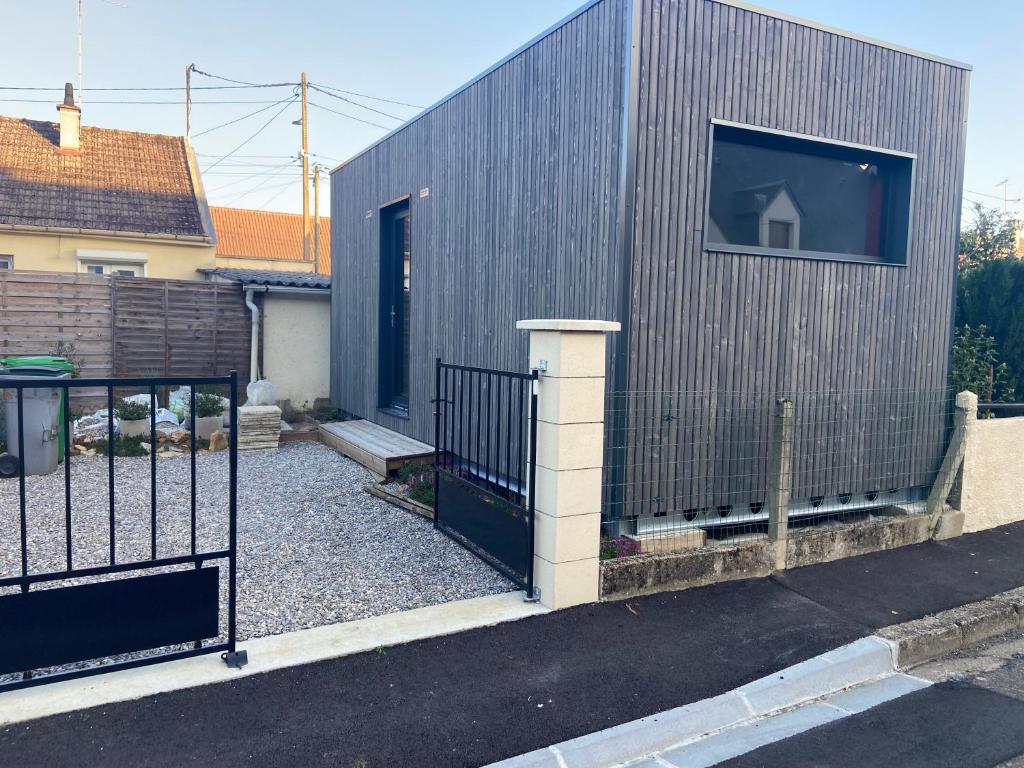 a metal building with a gate and a door at Studio atypique Le Mans in Le Mans