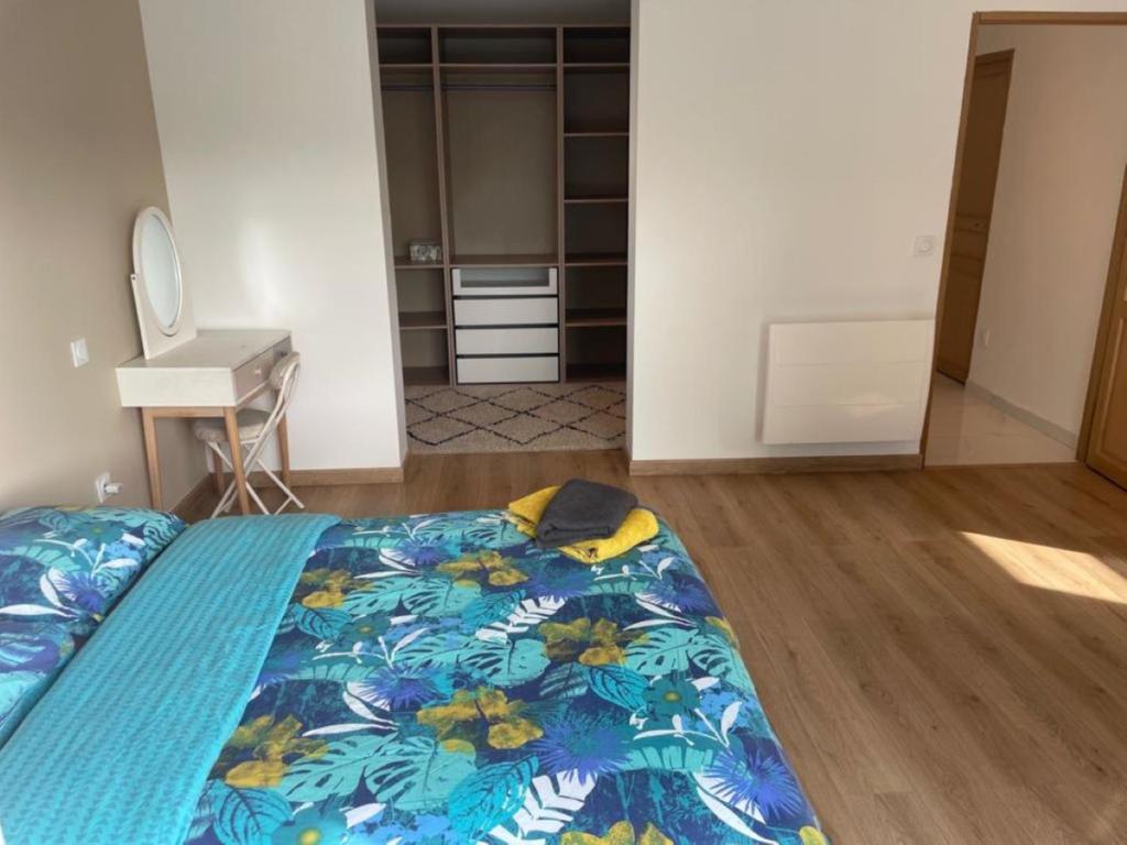 1 dormitorio con 1 cama con edredón azul en VILLA LENA, en Sainte-Geneviève-des-Bois