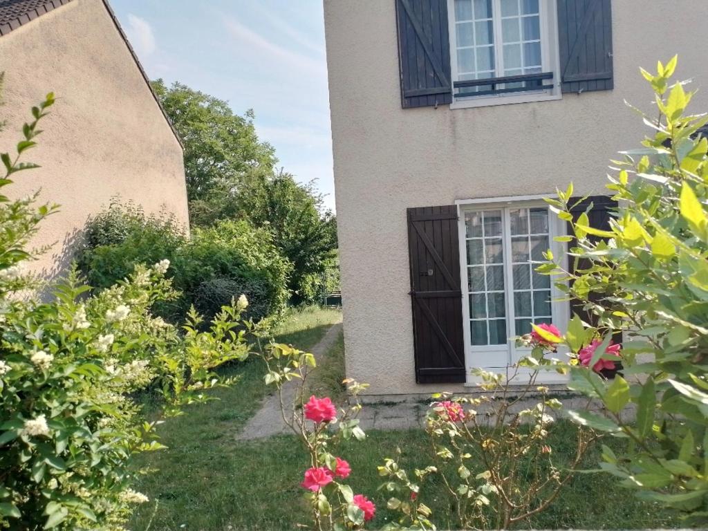 a house with a yard with flowers in front of it at Le Cocon Céleste à Longjumeau in Longjumeau