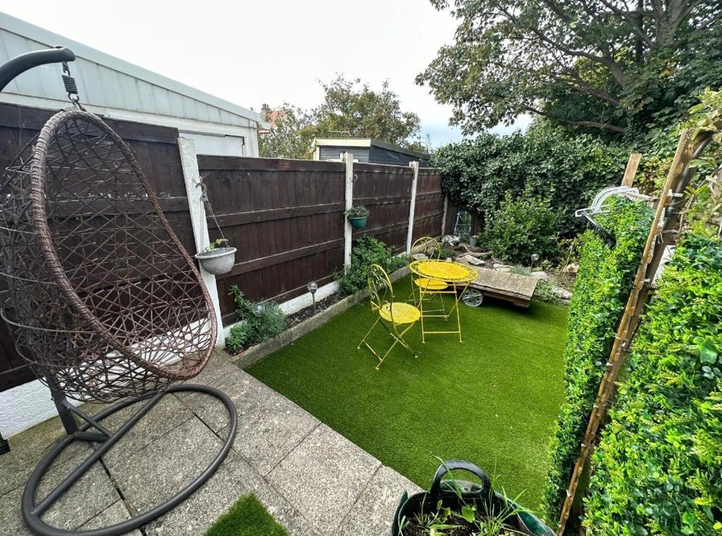 a backyard with a garden with a table and chairs at Beach retreat in Prestatyn