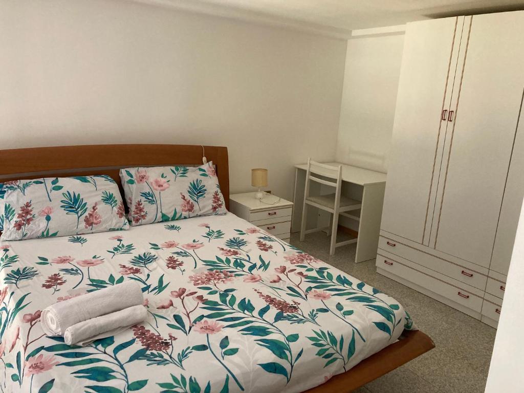 una camera da letto con un letto con copriletto floreale di james house blu a Teramo