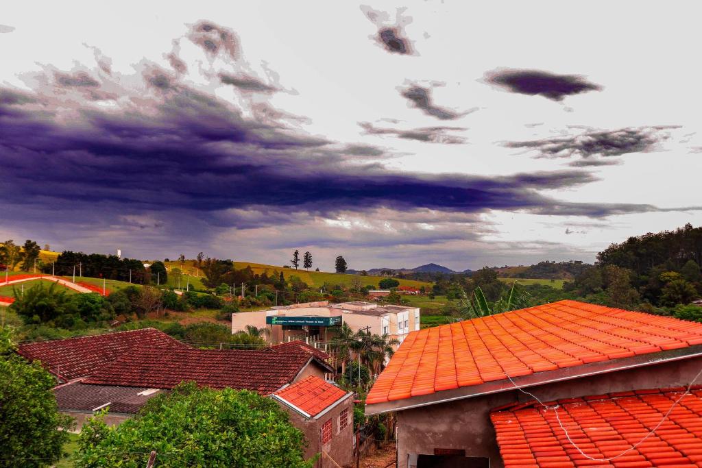 an orange roof on a building with a cloudy sky at Pousada Bela Vista in Inconfidentes