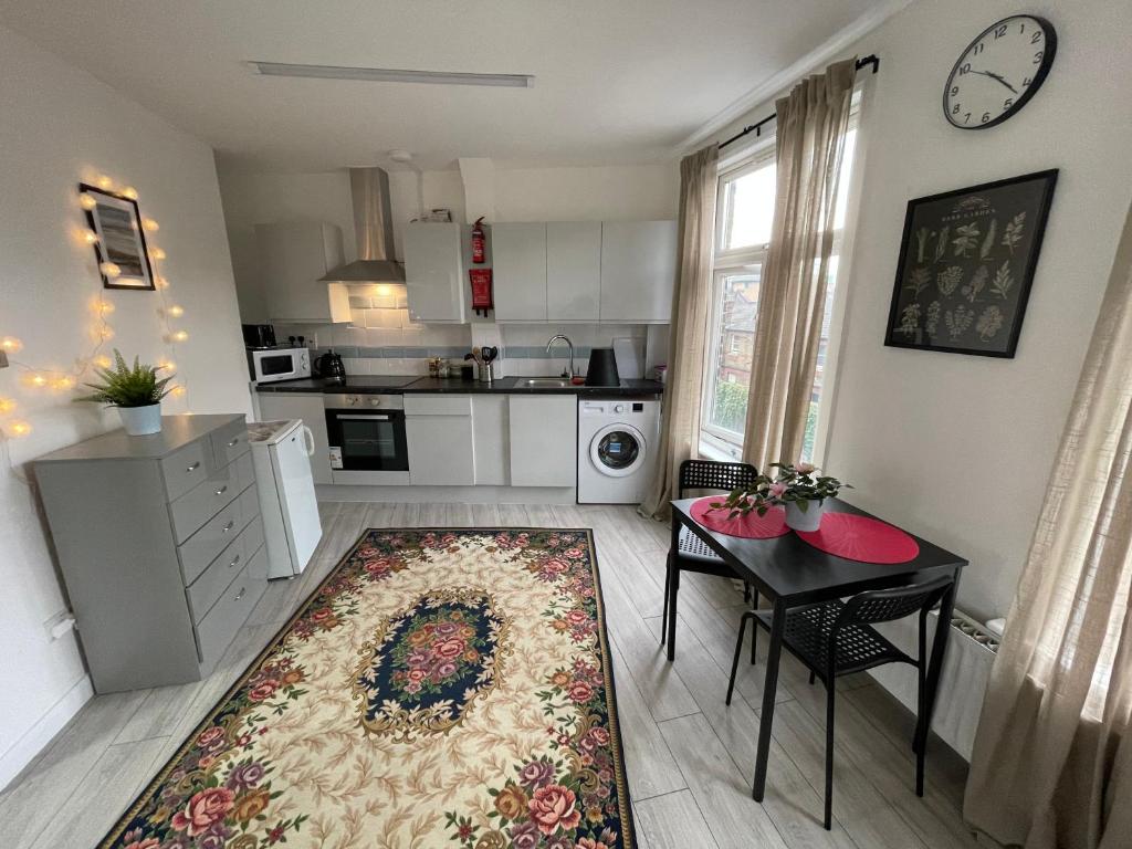 a kitchen with a table and a dining room at Luminous Family Flat (4 guests) in London