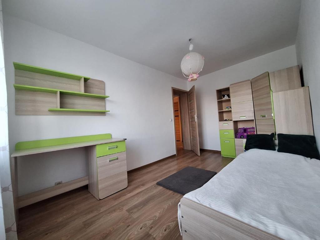 a bedroom with a bed and a desk in it at Apartament Maria 