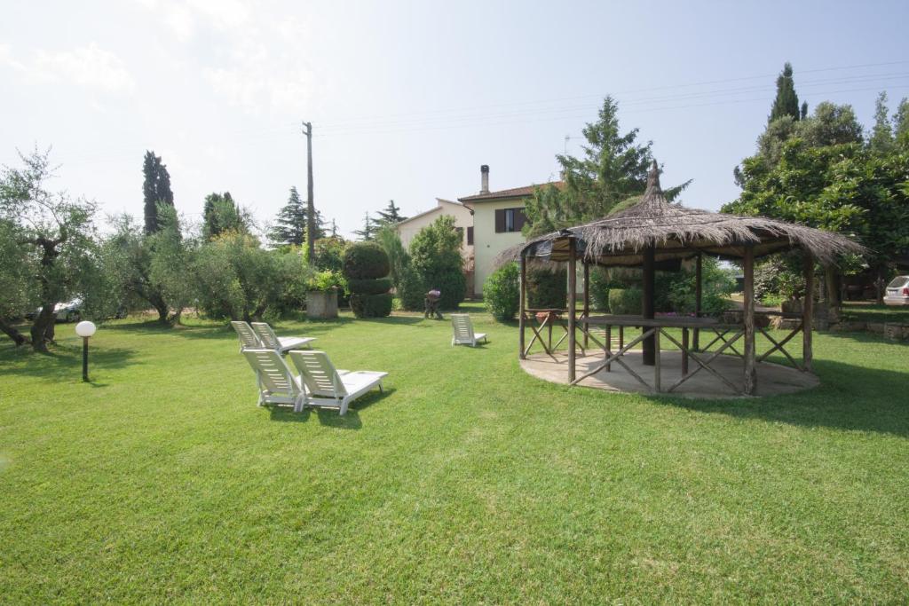 a gazebo with a group of chairs in a yard at Agriturismo La Gazzella in Cura Nuova