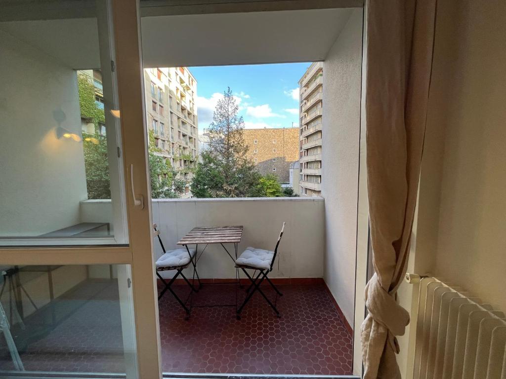 Un balcón con dos sillas y una mesa en un balcón. en Dream Dwell Paris -Studio with Balcony 800m to Trocadéro and Tour Eiffel, en París