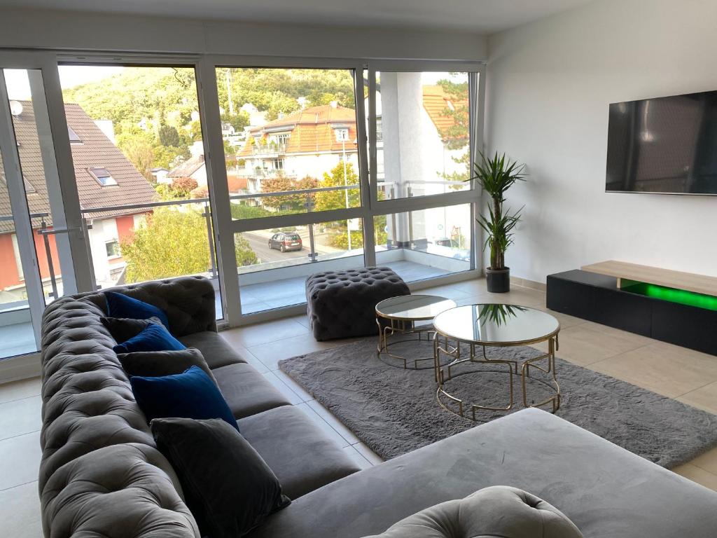 sala de estar con sofá y ventana grande en Valley of Business Frankfurt-West - Penthouse Nº1 - Three-Bedroom, en Hofheim am Taunus