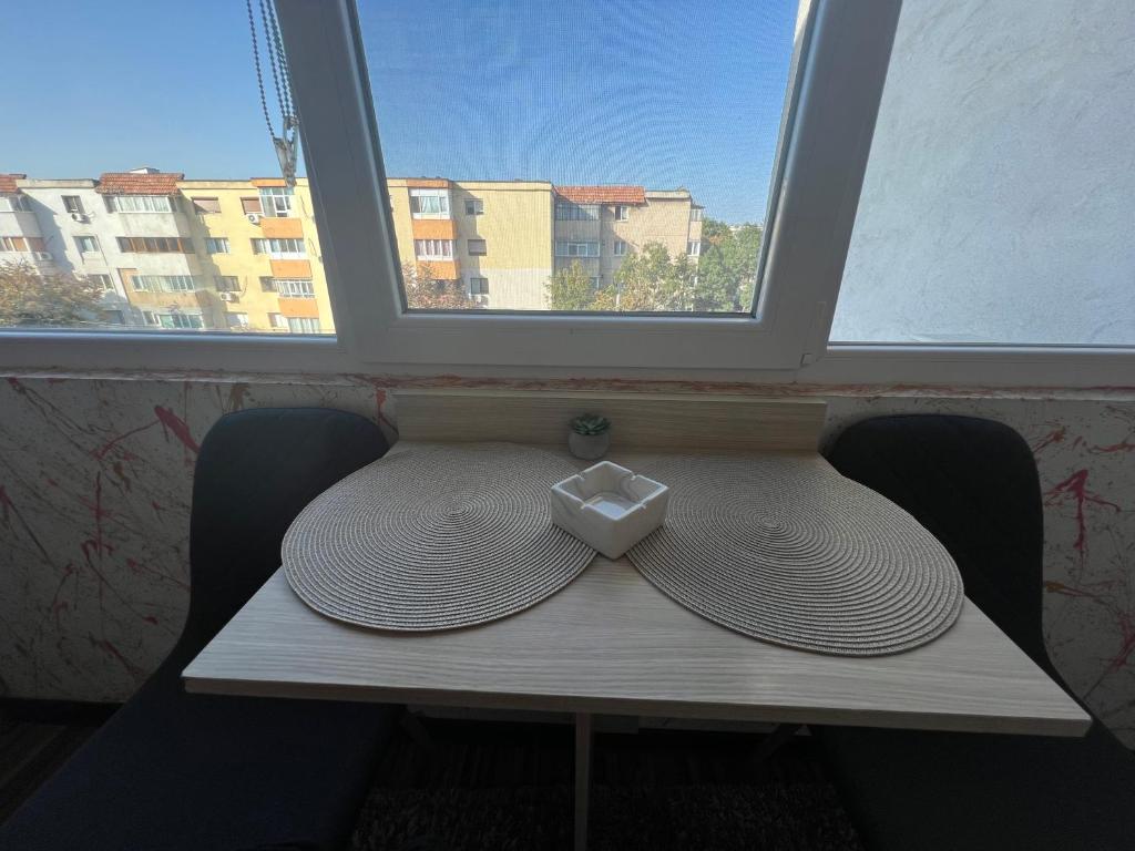 einen Hut auf einem Tisch im Fenster in der Unterkunft Apartament Wide View in Buzău