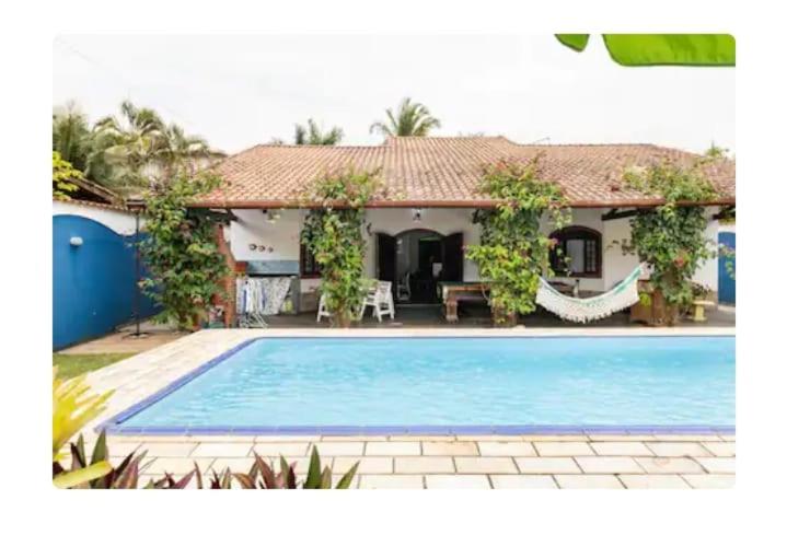 une maison avec une piscine en face de celle-ci dans l'établissement SUITES CONFORTÁVEIS CASAL OU QUATRO PESSOAS, à São Sebastião