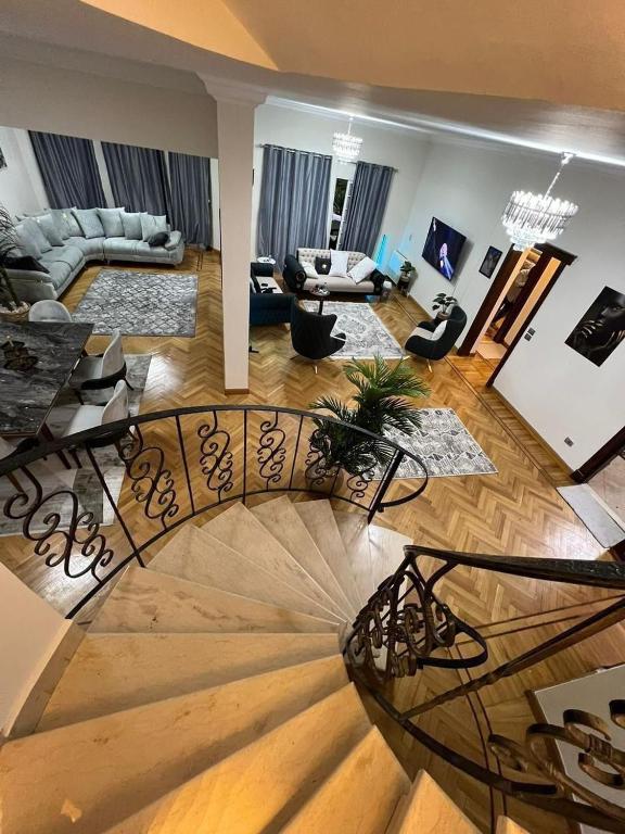 ein Wohnzimmer mit einer Wendeltreppe im Wohnzimmer in der Unterkunft Villa With A Private Garden In Beverly Hills in Madinat as-Sadis min Uktubar