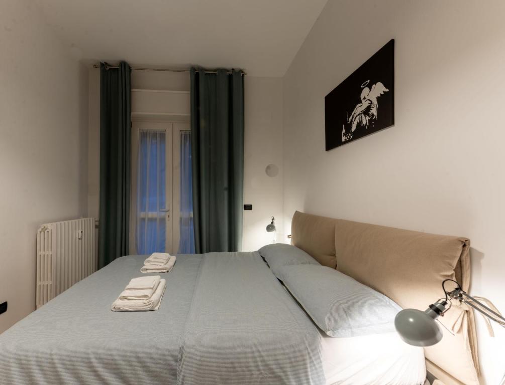 1 dormitorio con 1 cama con lámpara. en Holiday Apartment - Brescia centro - PARCHEGGIO PRIVATO, en Brescia