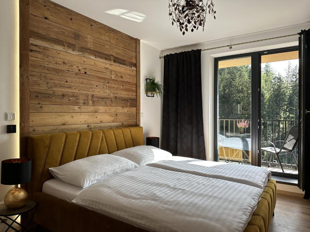 a bedroom with a large bed with a wooden headboard at Apartmány Černý důl - Horňák in Černý Dŭl