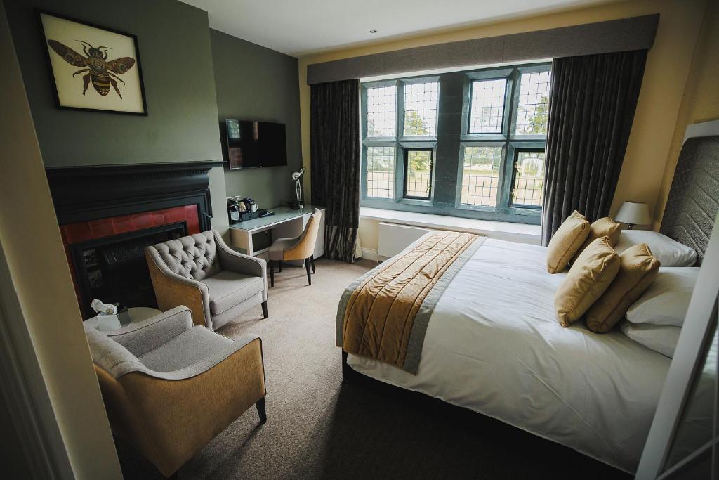 um quarto com uma cama, uma secretária e uma cadeira em Caer Rhun Hall Hotel em Conwy