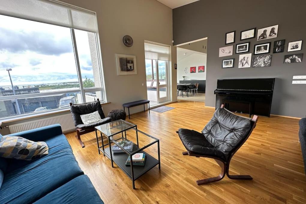 a living room with a blue couch and a piano at Spacious Family friendly house in the Reykjavik in Reykjavík