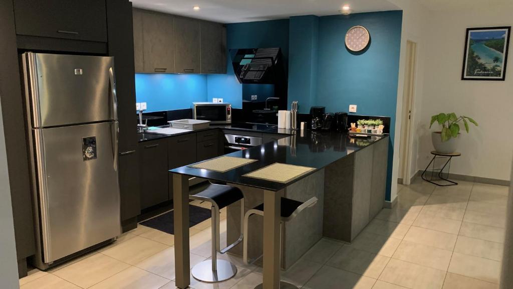 eine Küche mit einem Kühlschrank und einer Arbeitsplatte in der Unterkunft Kaili Ocean view luxury 2BR AC throughout Fiber Wifi & Pool in Papeete