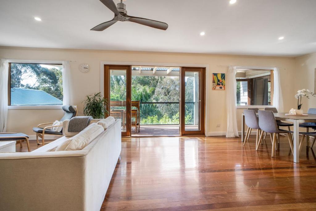 a living room with a couch and a ceiling fan at The Panoramic Tree View Home in Melbourne City in Melbourne