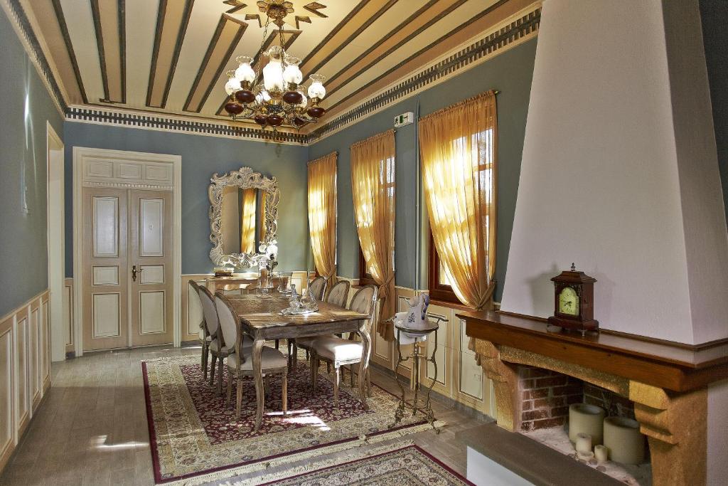 uma sala de jantar com uma mesa e cadeiras e uma lareira em Kastro Guesthouse em Ioannina