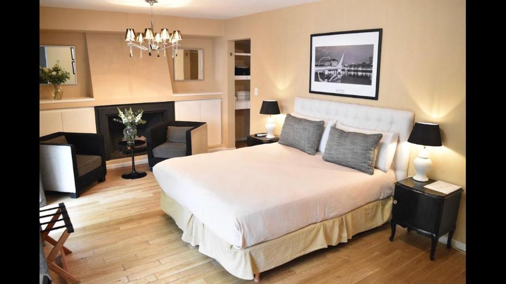 ein Schlafzimmer mit einem Bett und ein Wohnzimmer in der Unterkunft Maitre Hotel Boutique in Buenos Aires