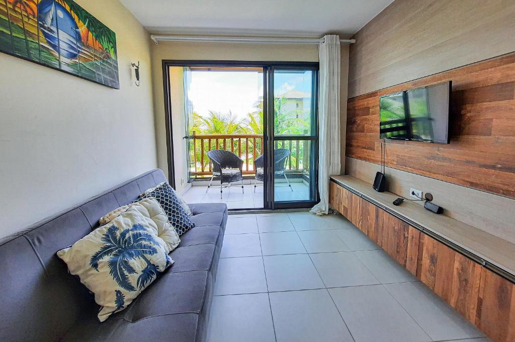 uma sala de estar com um sofá e uma televisão de ecrã plano em VG Sun Cumbuco 4 Pessoas Nascente WiFi em Cumbuco