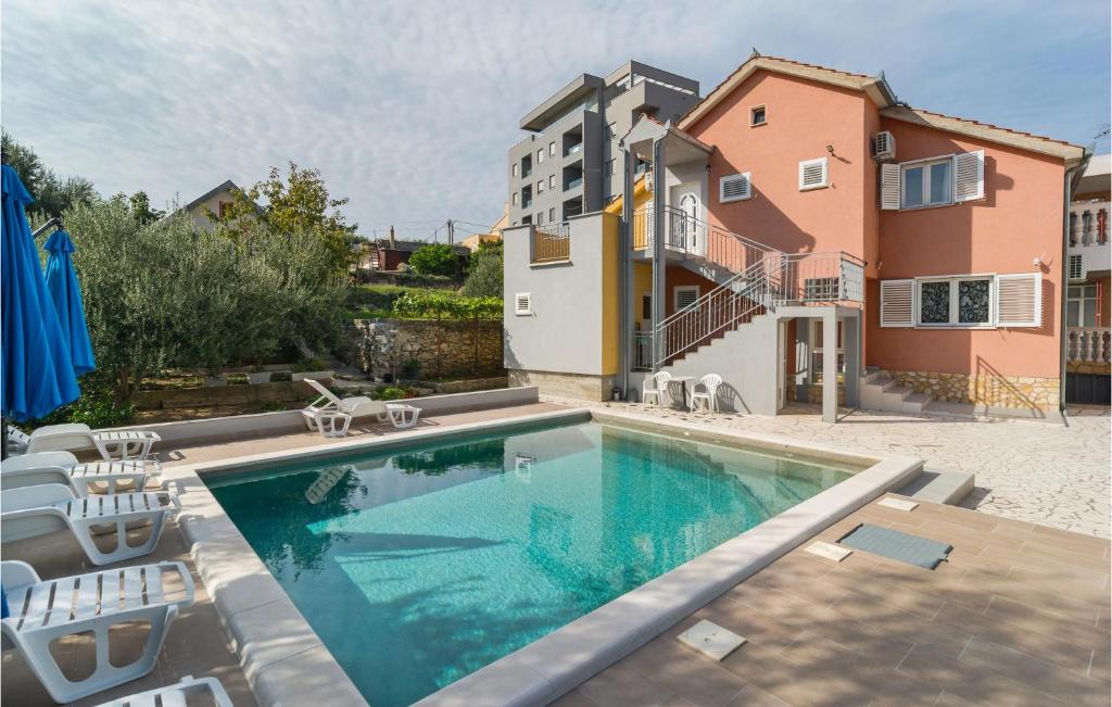 einen Pool mit Stühlen und ein Gebäude in der Unterkunft Beautiful Apartment In Split With Wi-fi in Split