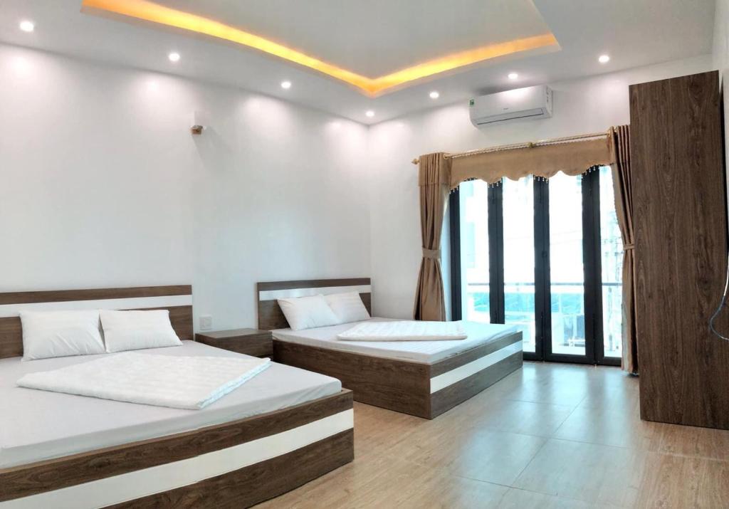 um quarto com 2 camas e uma grande janela em White's house em Quan Lan