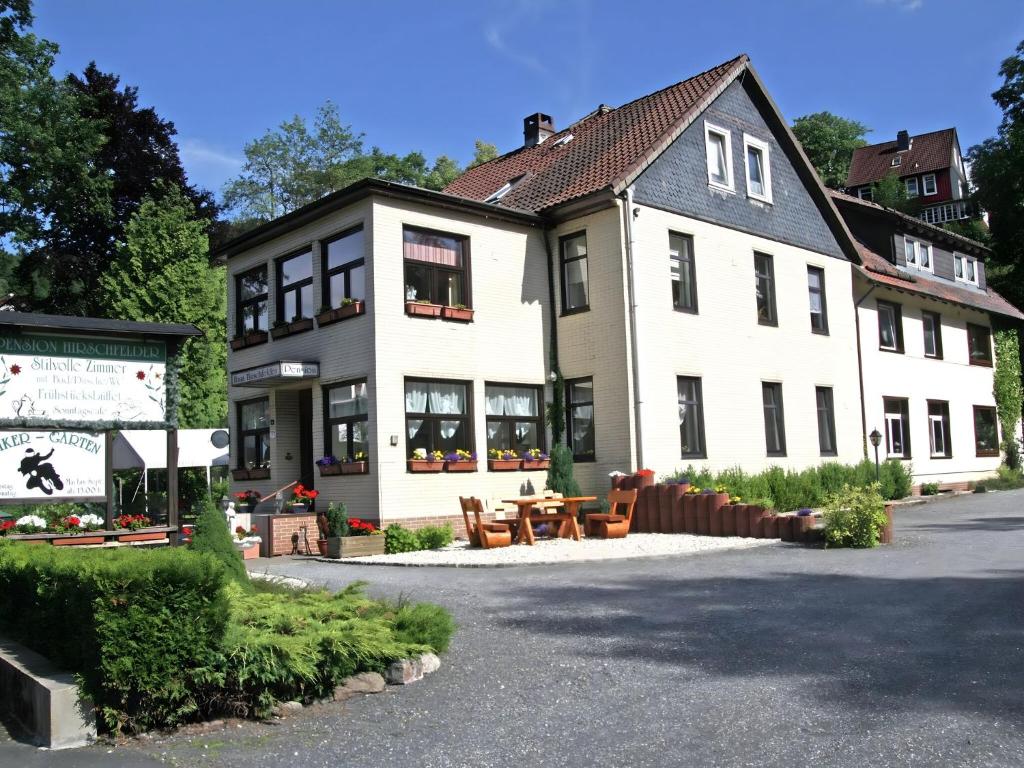 un gran edificio blanco con una mesa delante en Holiday apartment Stern in the heart of the Harz, en Wildemann