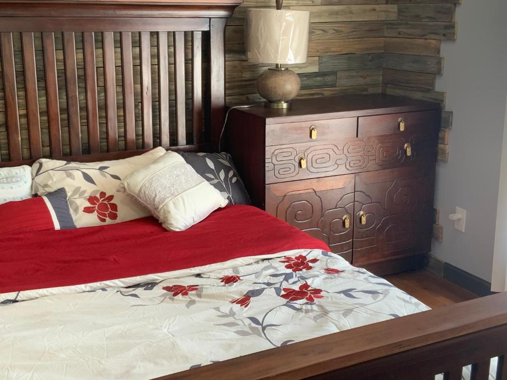 a bed with a red blanket and a wooden headboard at Cedar House in Rockaway Beach