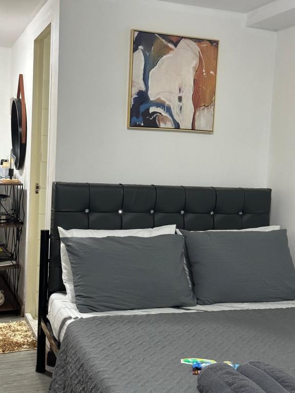 a bed with a black headboard in a bedroom at Condo in Ortigas in Manila