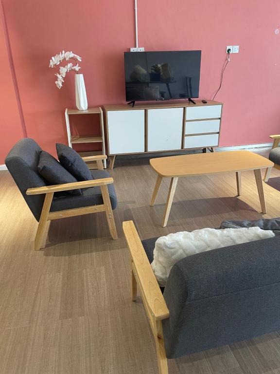 ein Wohnzimmer mit 2 Sofas und einem TV in der Unterkunft Theresa's Homestay in Tawau