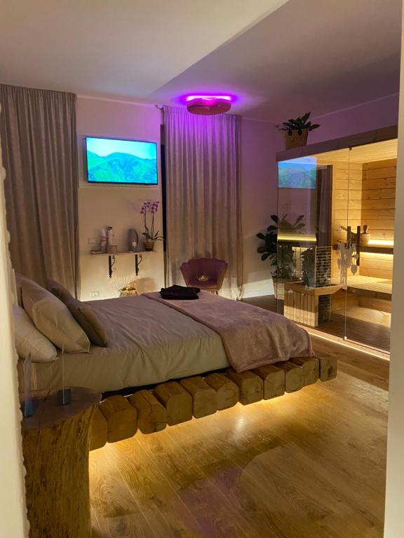 - une chambre avec un grand lit et un éclairage violet dans l'établissement Love Space Sensory Spa & relax suite, à Santa Maria delle Mole