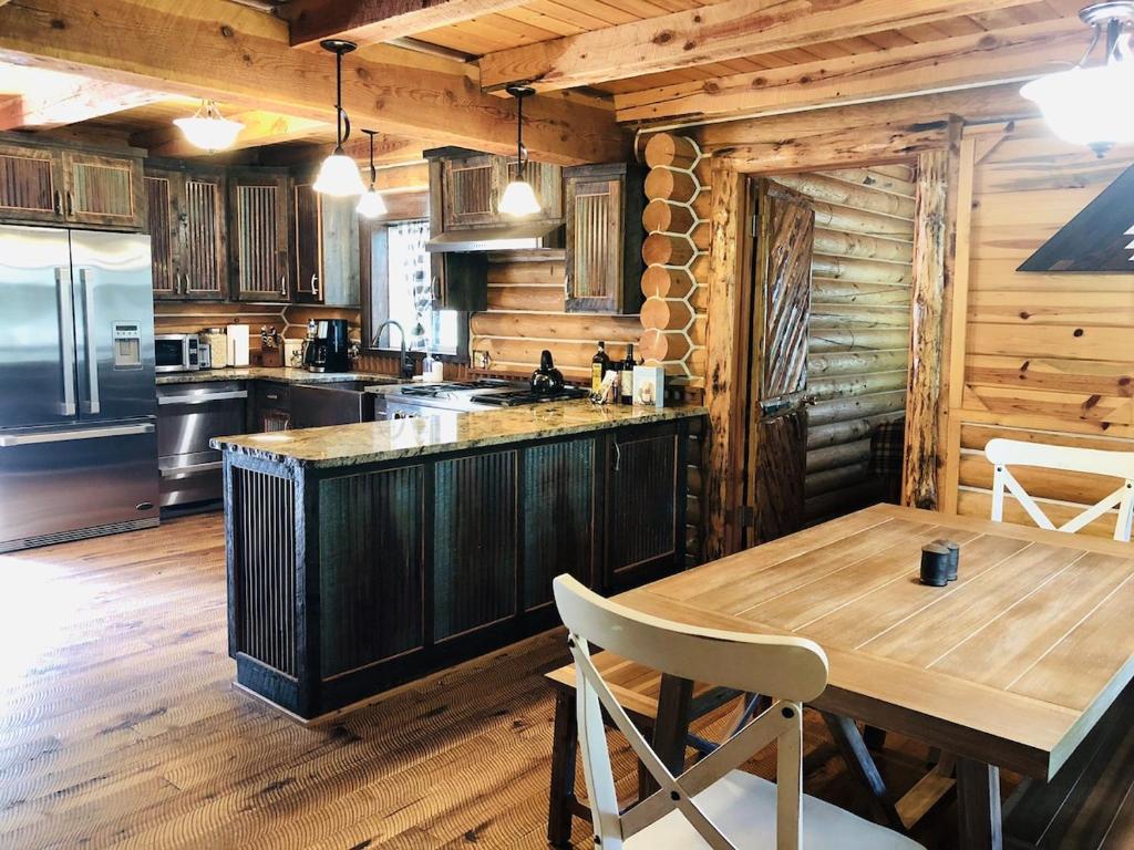 uma cozinha com uma mesa de madeira e uma bancada em 20 Mins To Ynp-cabin-pet Friendly em Island Park