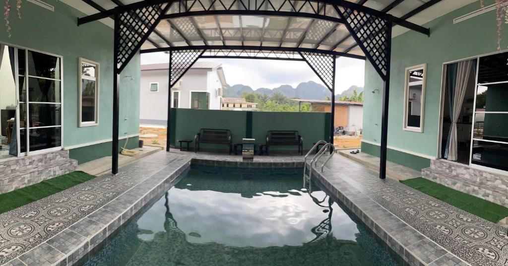 a house with a swimming pool in the yard at Teratak Sakinah Guest House in Tambun