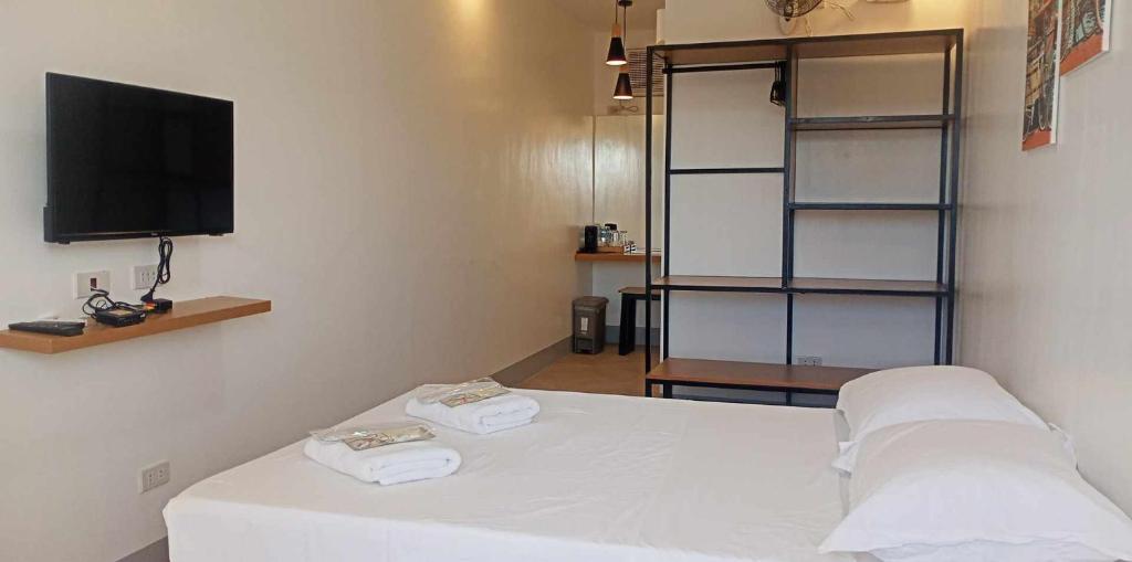 a room with a bed and a tv and shelves at MAMORI HOTEL in Allen