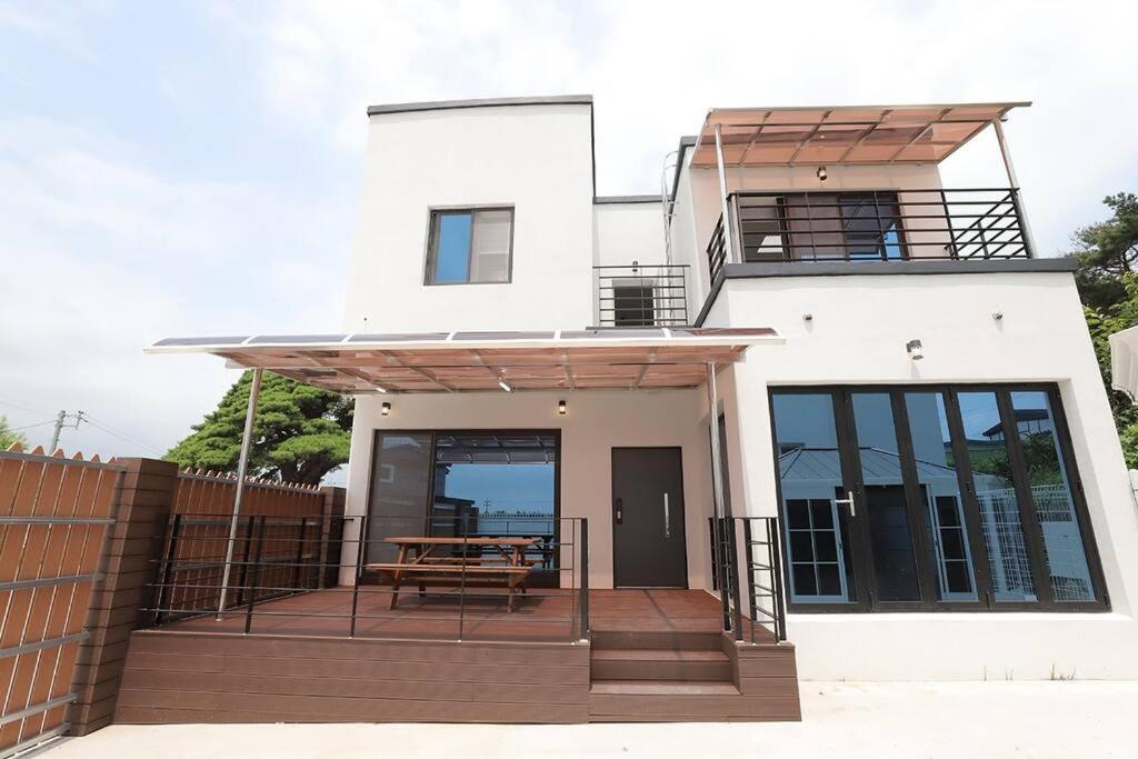 una casa con una terraza con una mesa. en WoW WoW Pool Villa en Gyeongju
