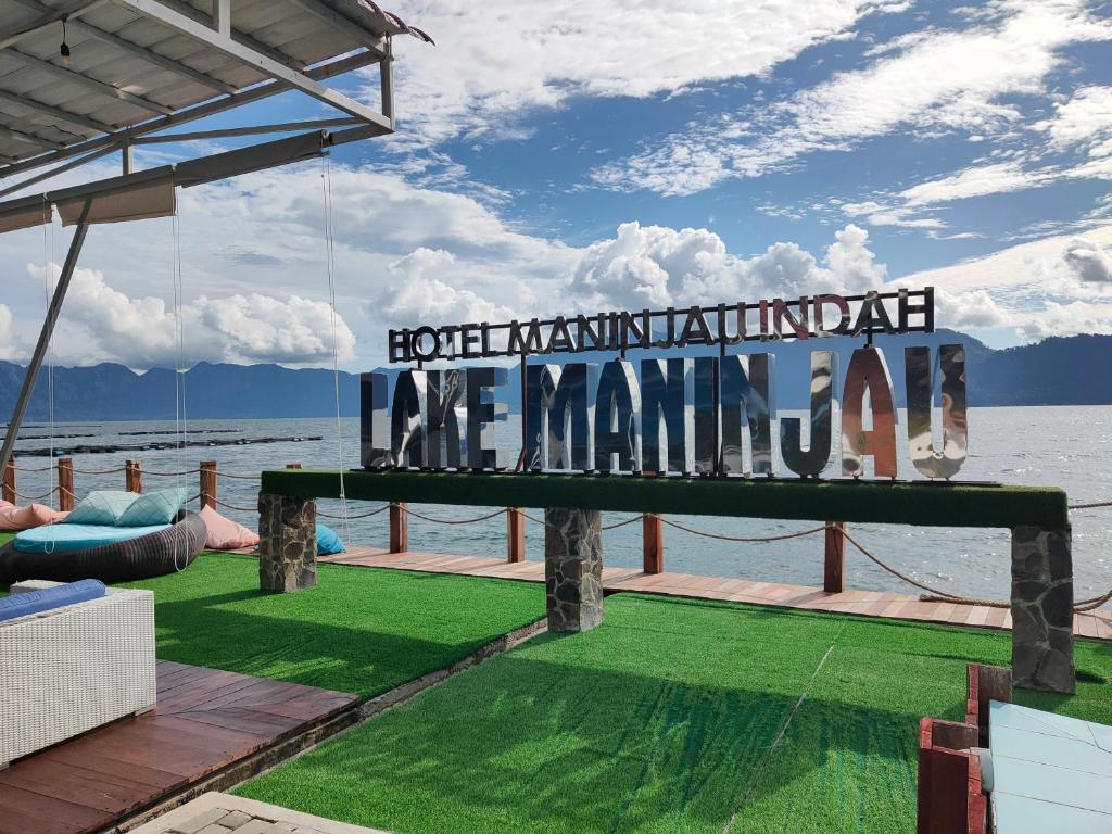 a sign on the deck of a house overlooking the water at Hotel Maninjau Indah - The Lakeside Resort in Maninjau