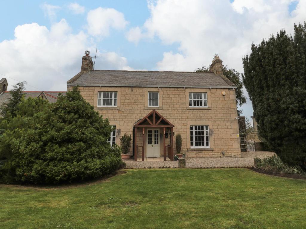 a large brick house with a large yard at Prudhoe Cottage in Prudhoe