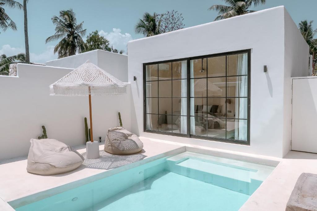 a villa with a swimming pool and a house at Cahaya Villas - Luxury Villa With Private Pool in Gili Trawangan