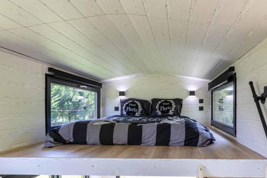 1 dormitorio en una casa pequeña con 1 cama en Mini maison Tiny house 6 per 3800m2 jardin Jacuzzi en Pontault-Combault