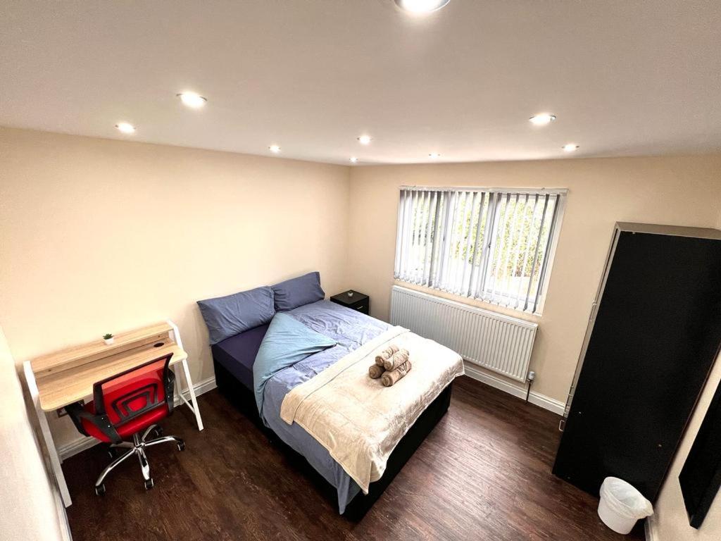 a small bedroom with a bed and a desk at Nines of Elegance At Castle Road in Birmingham