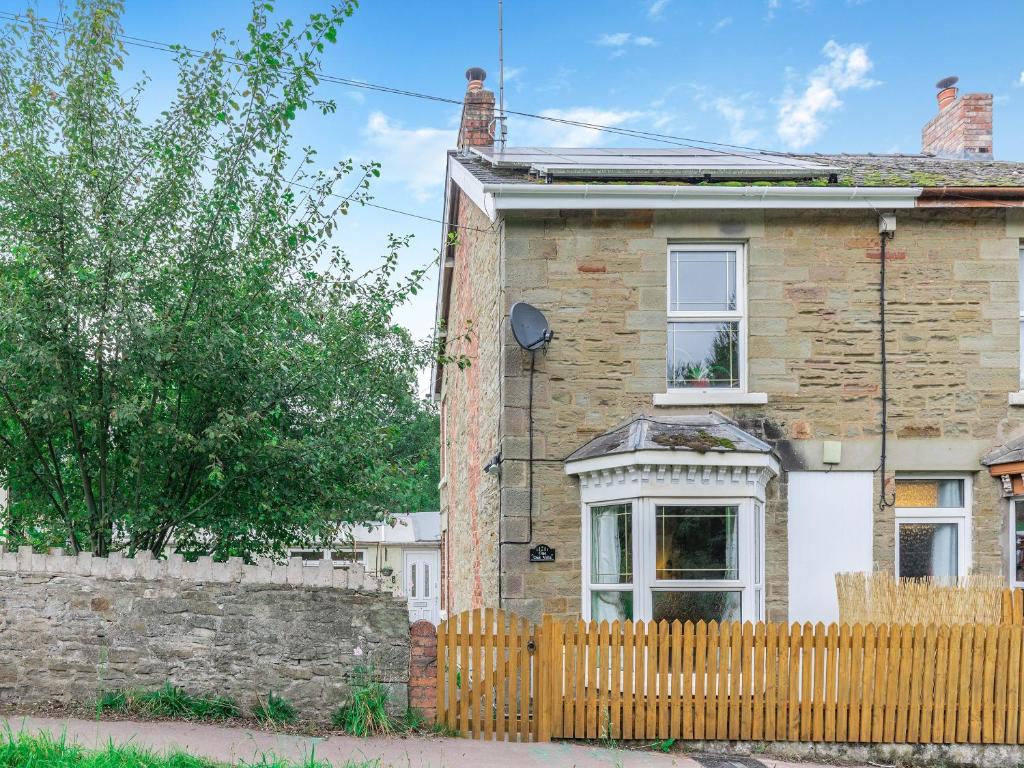 a brick house with a wooden fence in front of it at Oak Villa in Cinderford