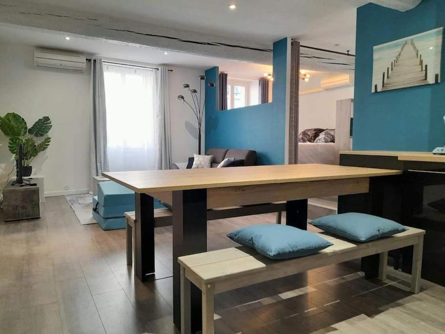sala de estar con mesa de madera y bancos en Superbe loft 52 m2 où tout est accessible à pied en Port-Vendres
