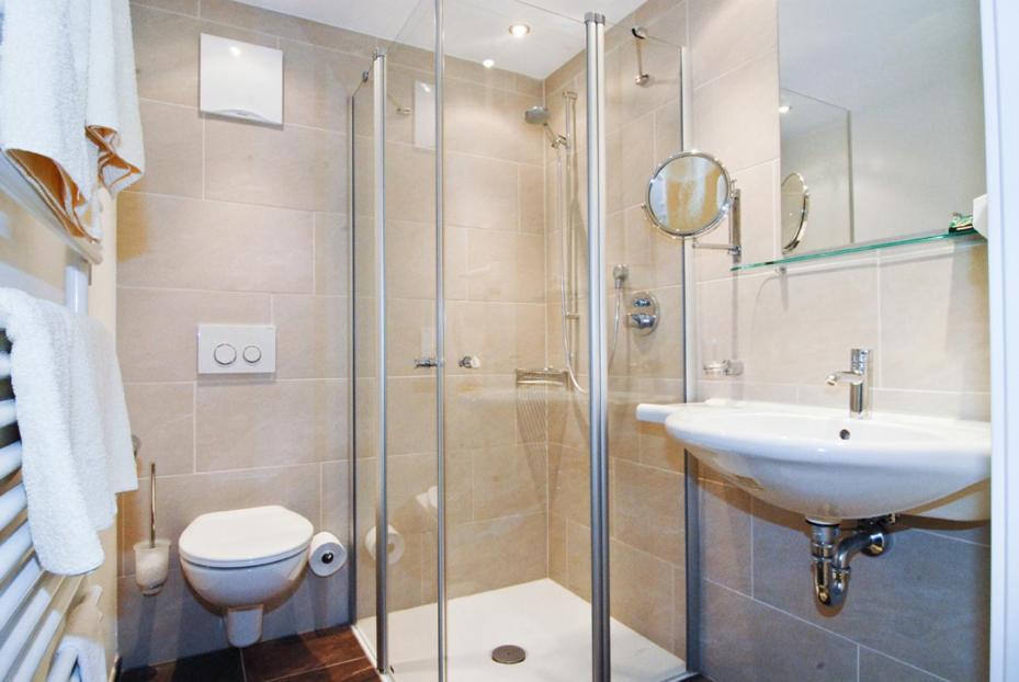 a bathroom with a shower and a toilet and a sink at Hotel Park in Sankt Johann in Tirol