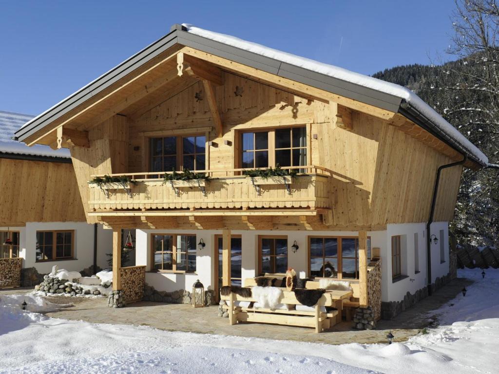 a large wooden house with a balcony on top at Great chalet in an idyllic location in Wagrain in Wagrain