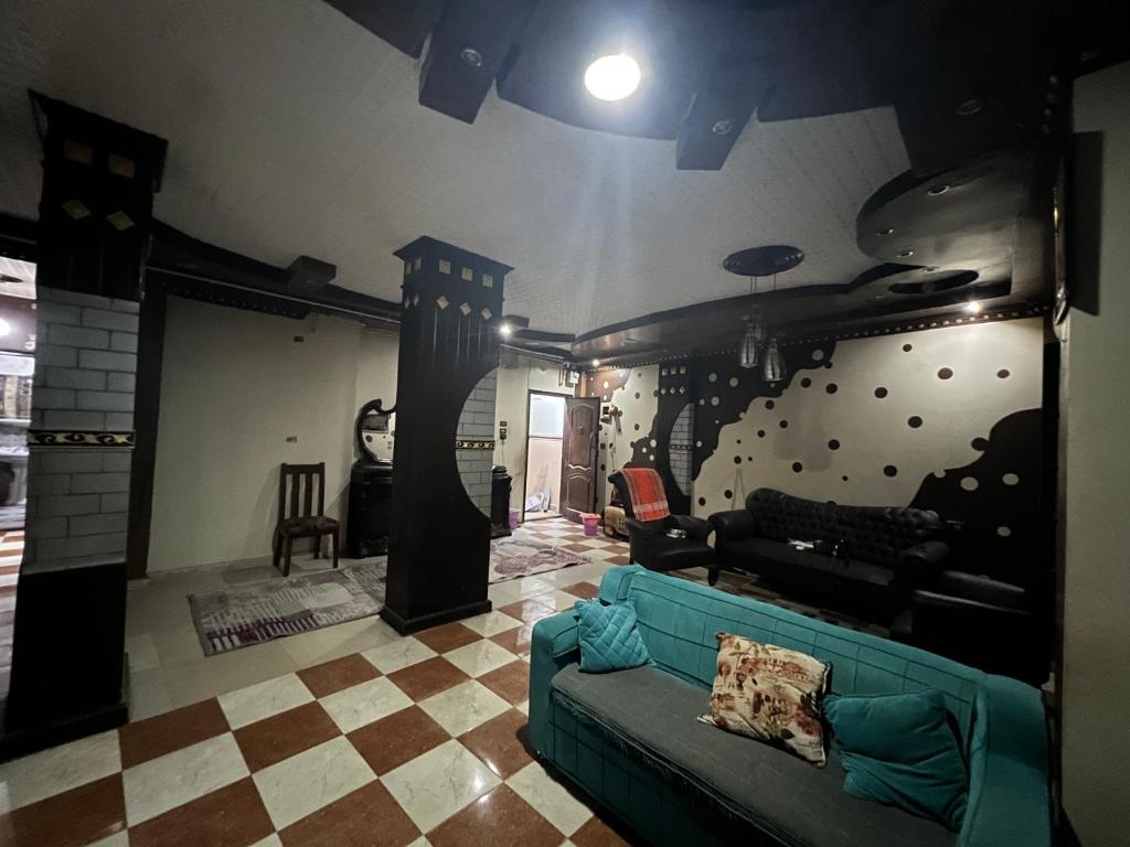 a living room with a couch and a wall with planets at شقه ثلاثه غرف وريسبشن ثلاثه قطع لك بالكامل بها تكييف ف الصاله in Mansoura