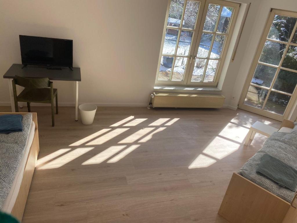 a living room with sun shining through the windows at Gästehaus am Biener See in Schepsdorf