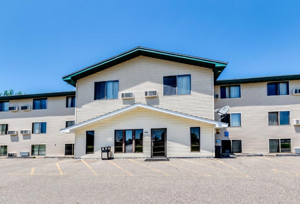 a large white building with a parking lot at Motel 6-Albert Lea, MN in Albert Lea